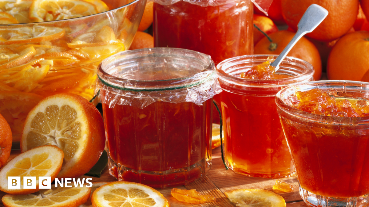Jars of marmalade with Seville oranges in the background