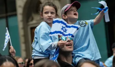 Two young children holding an Israeli flag.