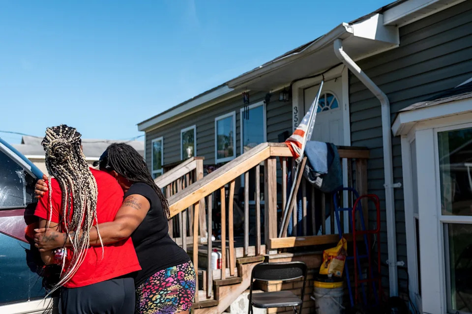 Brandon Bell/Getty Images - PHOTO: Syrnerica Pugh is comforted while grieving the death of her nieces and nephews, April 19, 2026, in Shreveport, Louisiana.