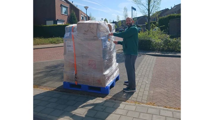 The author's husband standing next to the pallet containing everything they brought with them to the Netherlands.