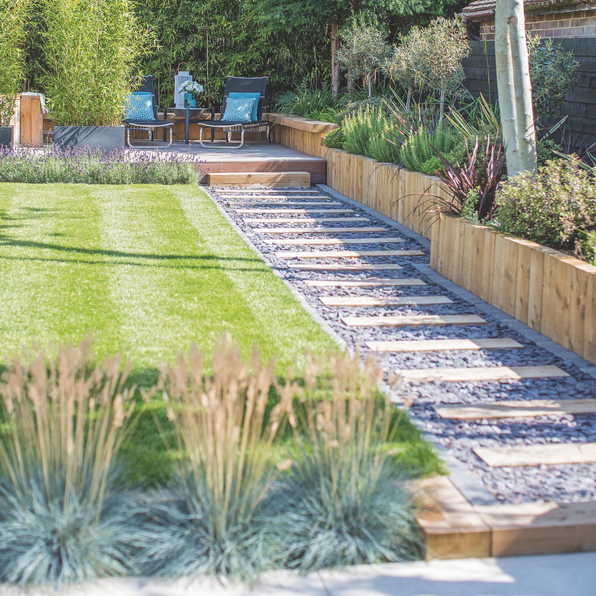 Landscaped garden with stripey lawn and a path running to the back of the garden