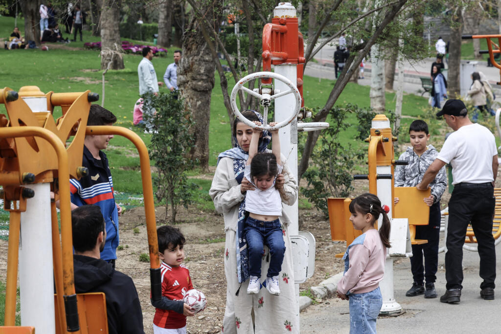 Children play on workout equipment at Tehran's Melat park during 'Sizdeh Bedar' (Nature Day), the 13th day after the Nowruz Persian New Year