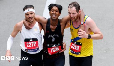Grace Chambers smiling at the camera, she has white hair. People are standing behind her.