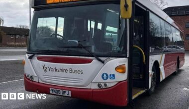 A parked bus owned by firm Yorkshire Buses in a red and white livery.