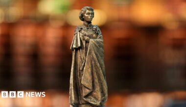 A bronze statue of Queen Elizabeth II in a model of St James's Park in London