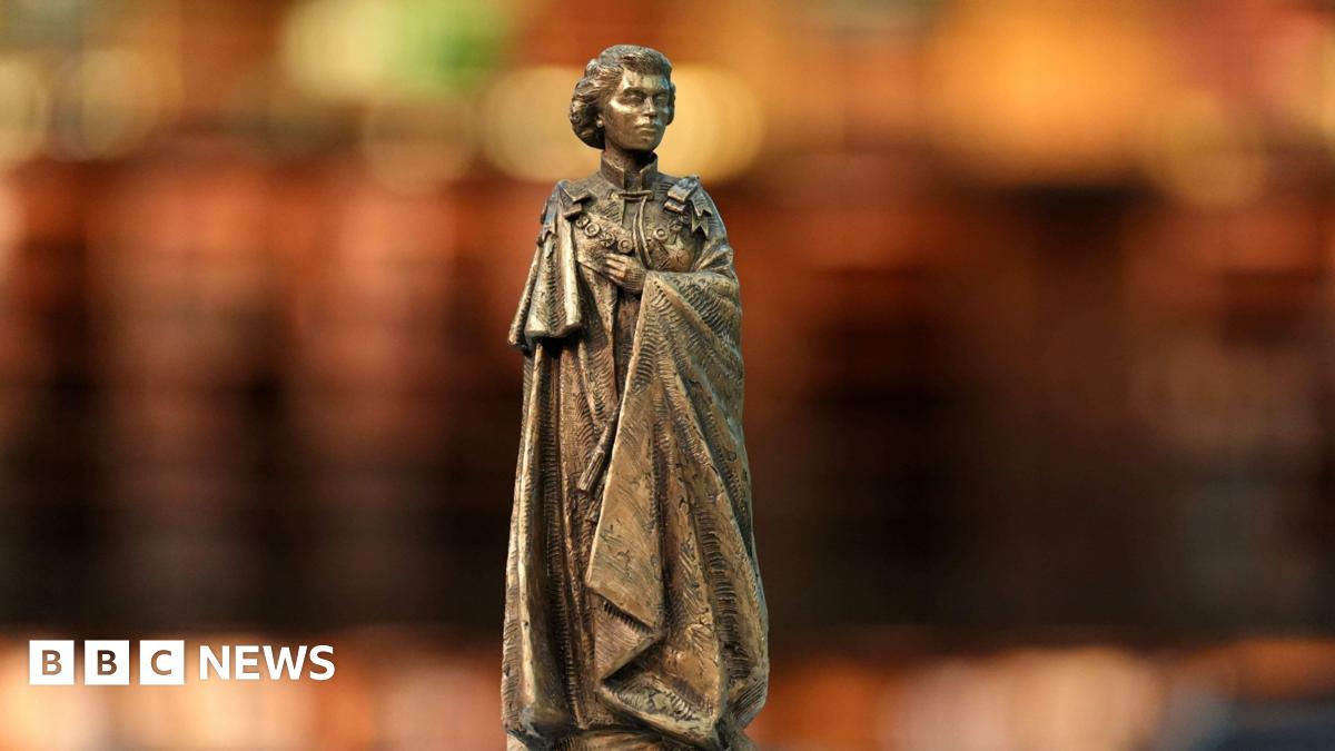 A bronze statue of Queen Elizabeth II in a model of St James's Park in London