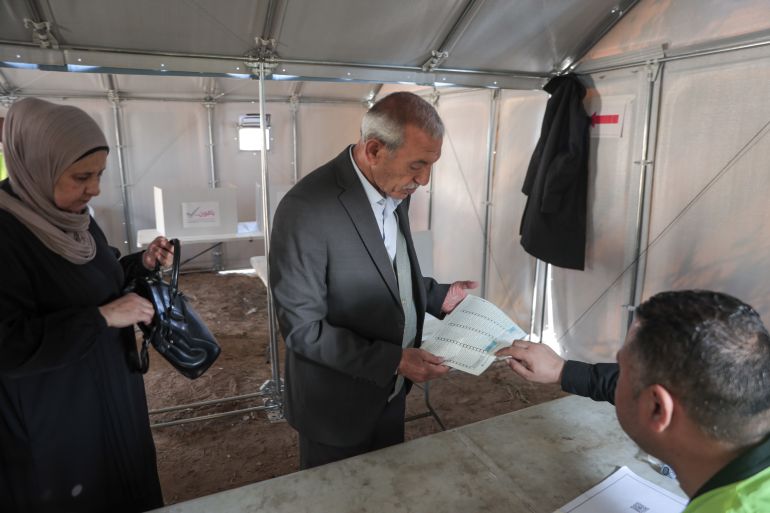 Awda Abu Baraka, 73, votes at a polling station center in Deir al-Balah [Abdelhakim Abu Riash/ Al Jazeera]