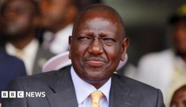 A close-up of President William Ruto in a grey suit, blue shirt and dotted tie during a past public event in Nairobi.