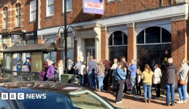 A queue of people outside a shop.