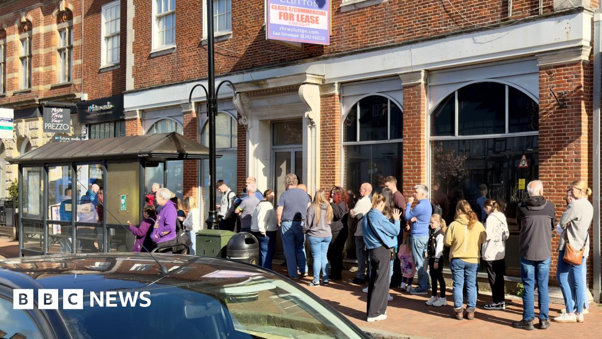 A queue of people outside a shop.