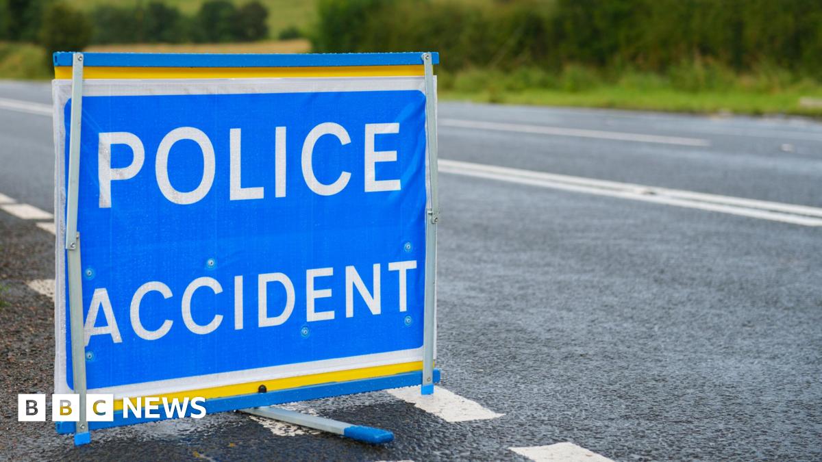 A blue police accident sign is placed in the carriageway of a road.