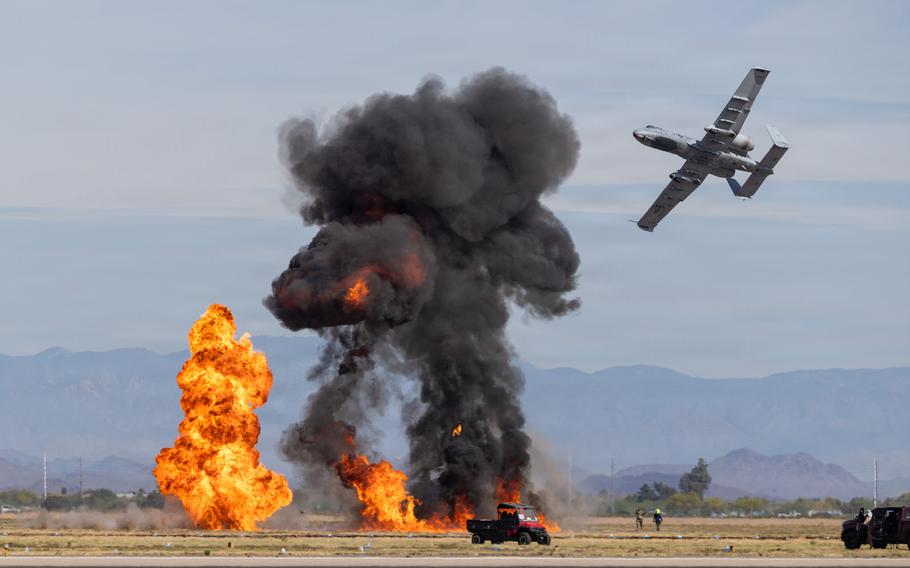 Flames and smoke on the ground as the A-10 flies close by.