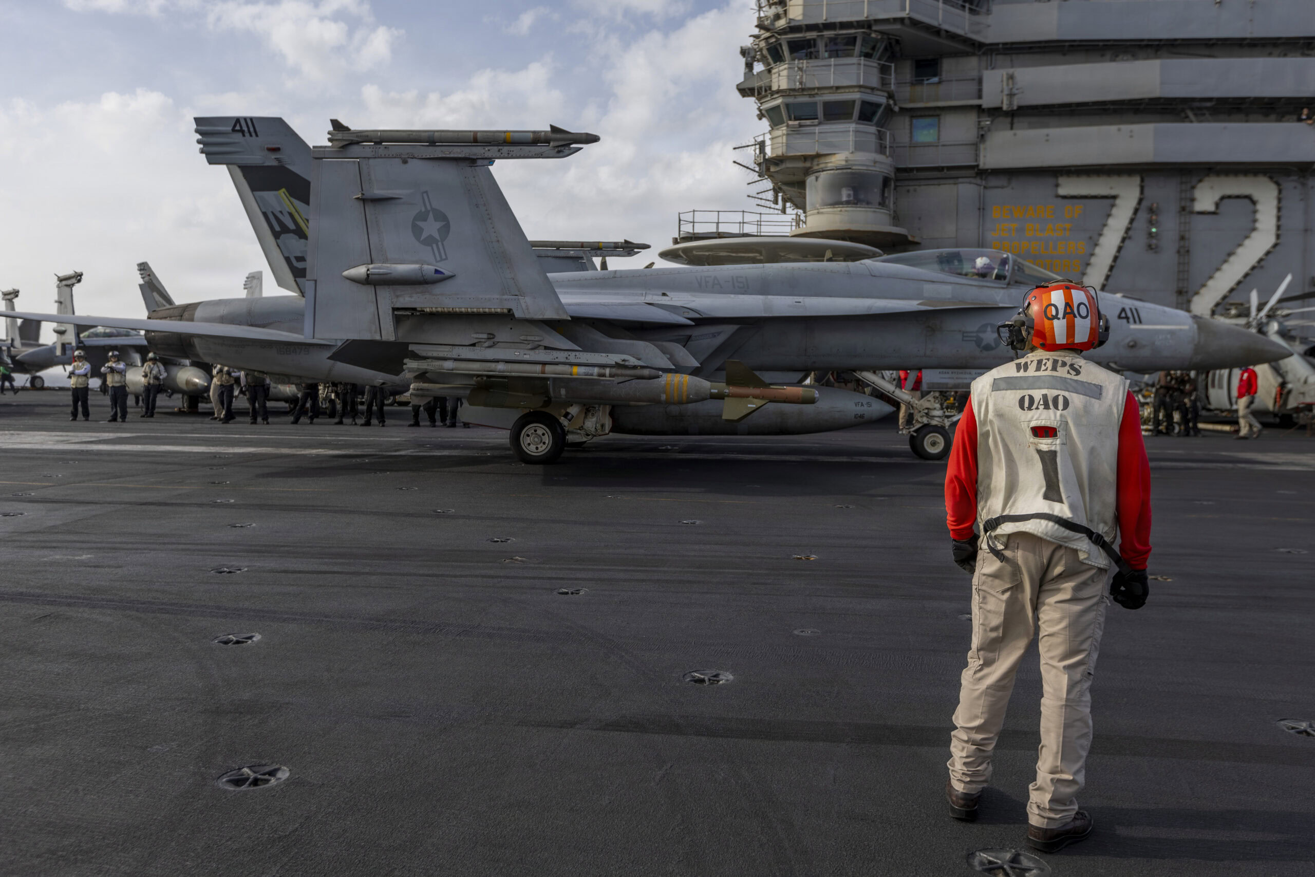 A U.S. Sailor observes an F/A-18E Super Hornet, attached to Strike Fighter Squadron (VFA) 151, prepare for flight operations on the flight deck of Nimitz-class aircraft carrier USS Abraham Lincoln (CVN 72) during Operation Epic Fury, March 30, 2026. (U.S. Navy photo)