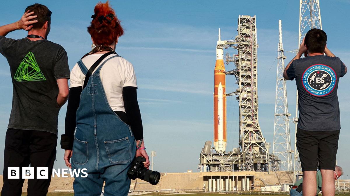 Employees from the Johnson Space Center hold signs along Brantly Avenue near Ellington Field as they gather to send off the Artemis II astronauts ahead of their mission to the moon in Houston, Friday, March 27, 2026.