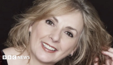 A close up image of Moya Brennan smiling at the camera. She has blonde hair and brown eyes.