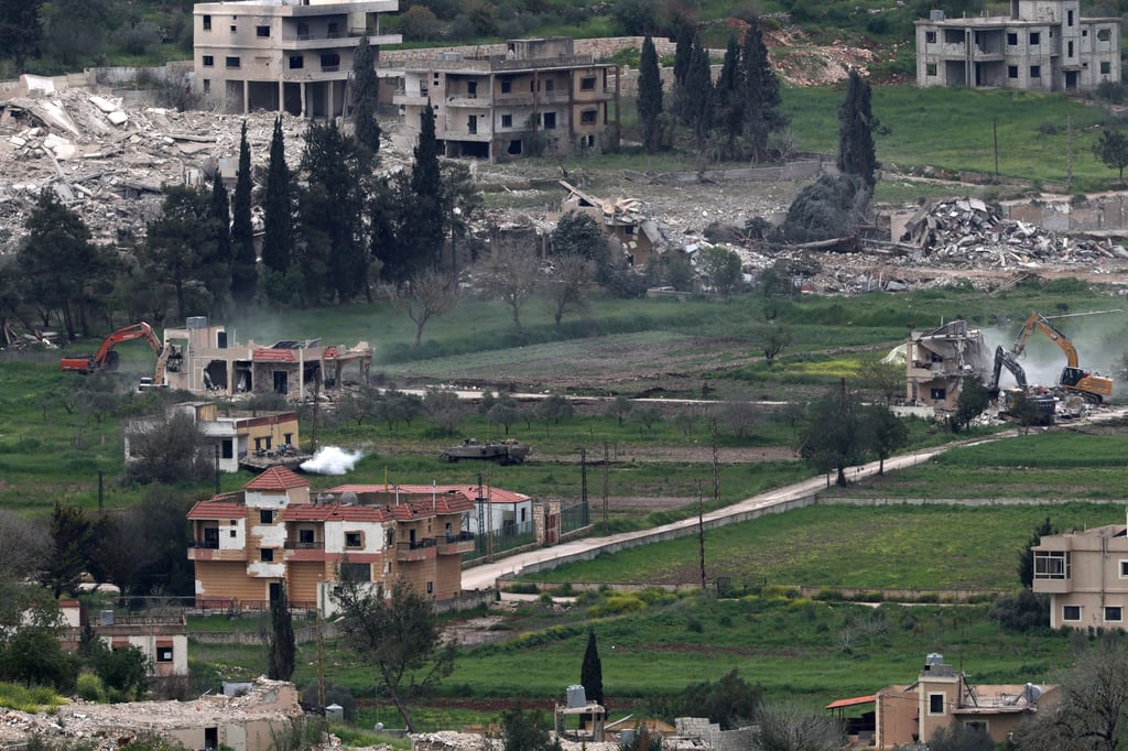 Israeli armoured personnel carriers guard excavators demolishing buildings in the southern Lebanese village of Mais al-Jabal, as seen from the Israeli side of the border, on Wednesday. Photo: EPA