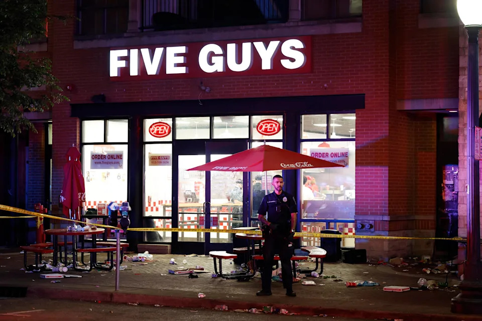A police officer stands on patrol outside a Five Guys store during an investigation following a shooting on Kirkwood Avenue on April 26, 2026, in Bloomington, Indiana. / Credit: Jeremy Hogan / Getty Images