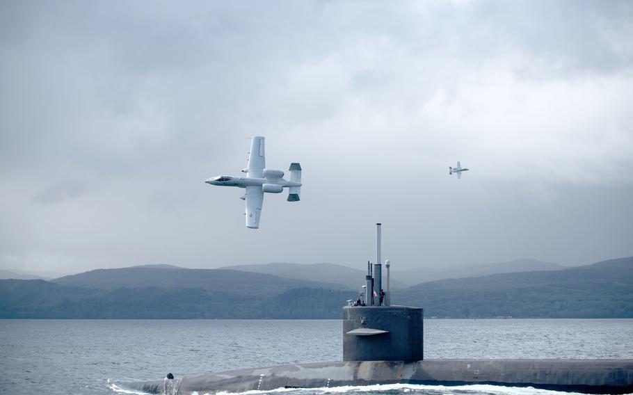 The submarine surfaces with the A-10 flying above.