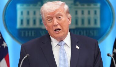 A man in a suit and tie speaks at a podium, with the White House emblem visible in the background.