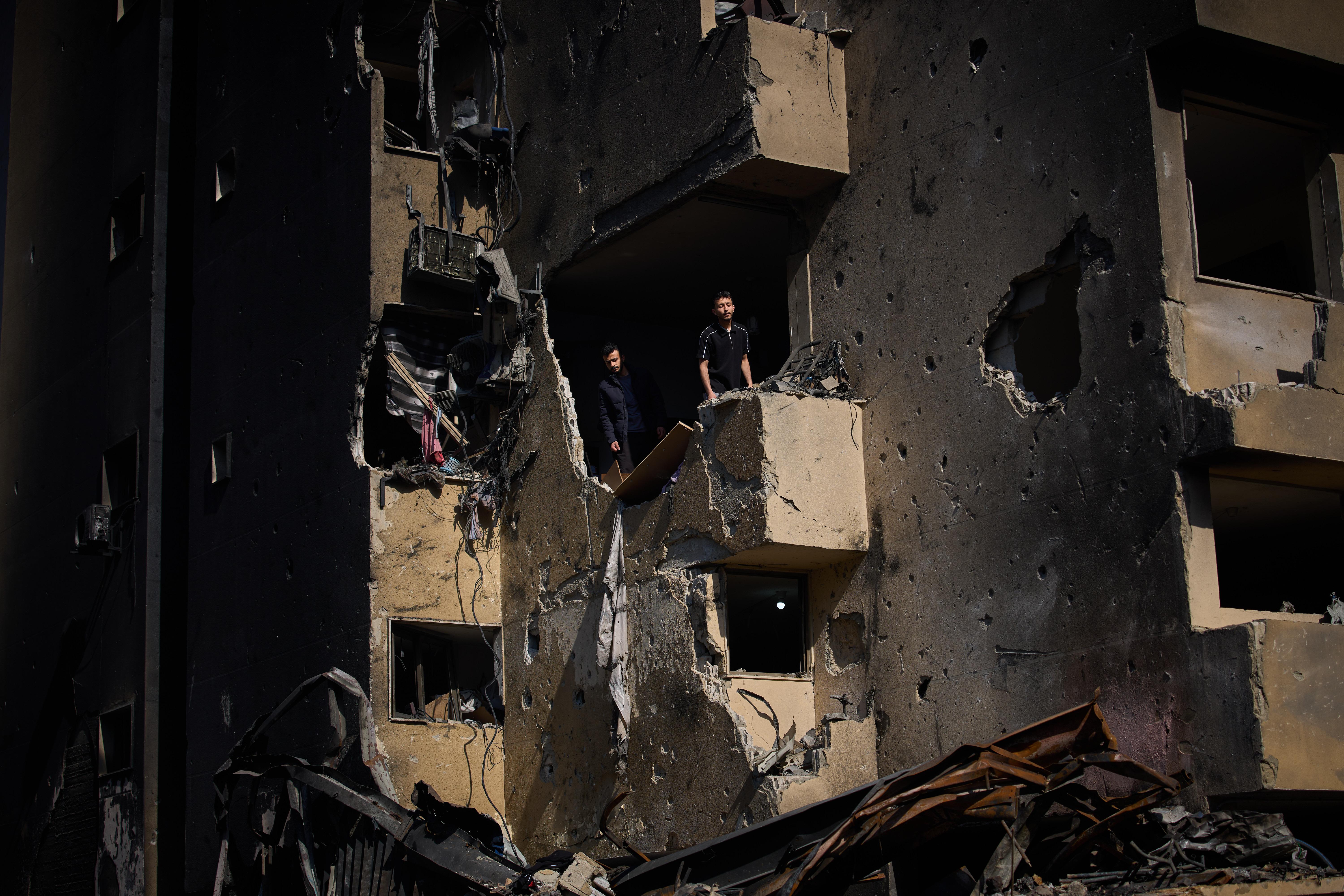 Men inspect the damage to their home destroyed in an Israeli airstrike in Beirut.