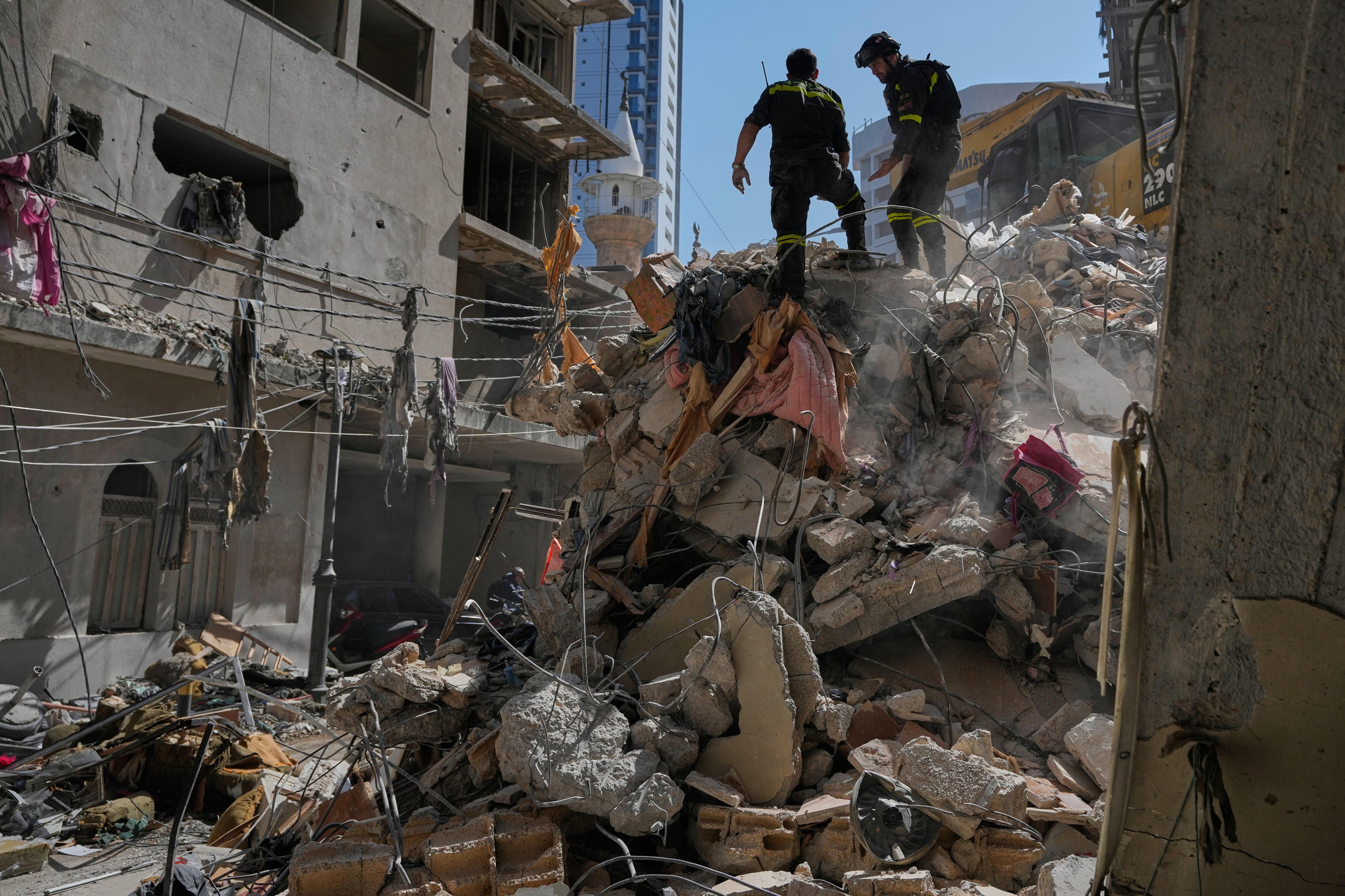 Lebanese civil defense workers inspect a building destroyed in an Israeli airstrike.