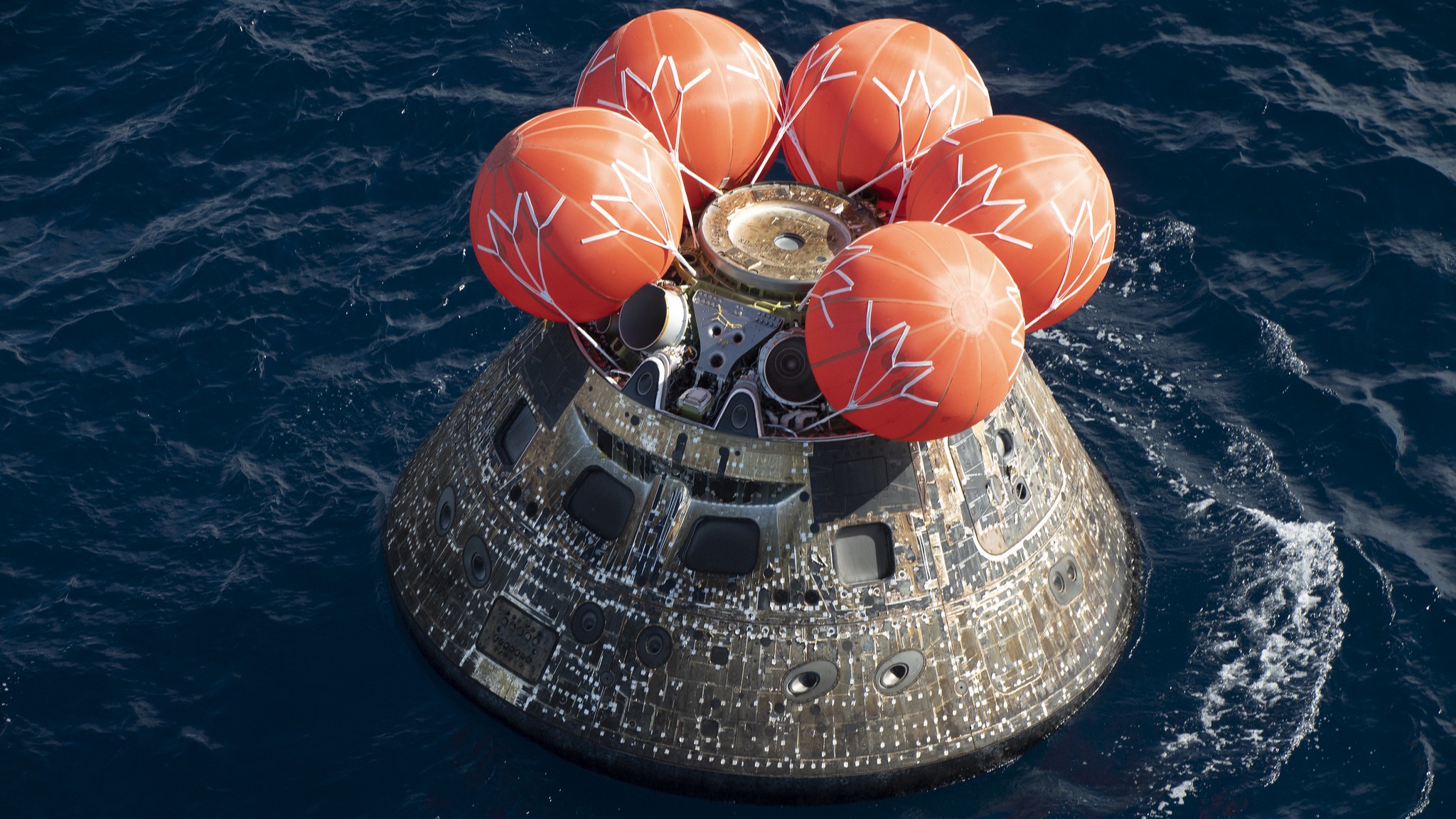 A photo of the Artemis I Orion capsule in the ocean after splashdown.