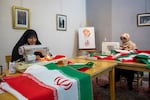 Volunteers sew Iranian flags to distribute across the city for free in Tehran, Iran, on Sunday. According to the team's manager, up to 5,000 flags are distributed daily.