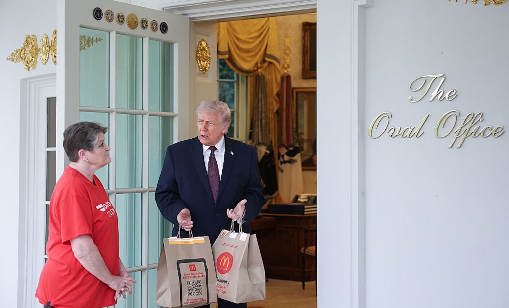 President Donald Trump receives a DoorDash delivery at the Oval Office from Sharon Simmons (Win McNamee/Getty Images)