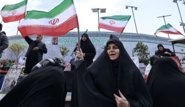 Carla Anne Robbins in black and white over a blue graphic design background