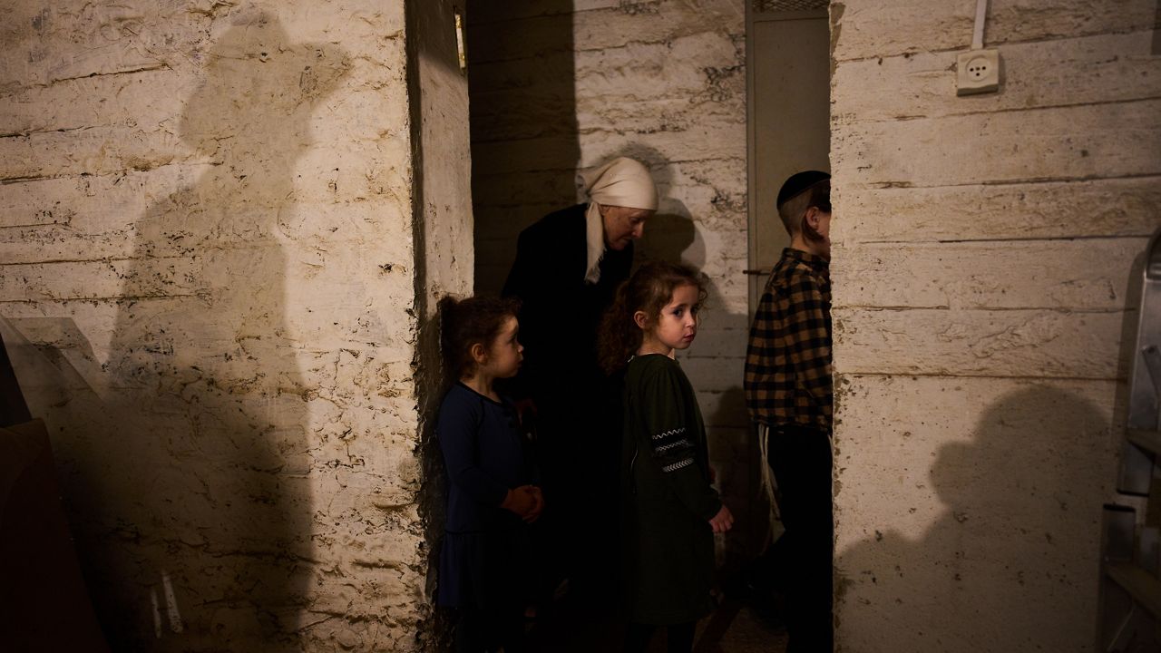 People take cover in a bomb shelter as air raid sirens warn of incoming Iranian missile strikes in Bnei Brak, Israel, Wednesday, April 1, 2026. (AP Photo/Oded Balilty)