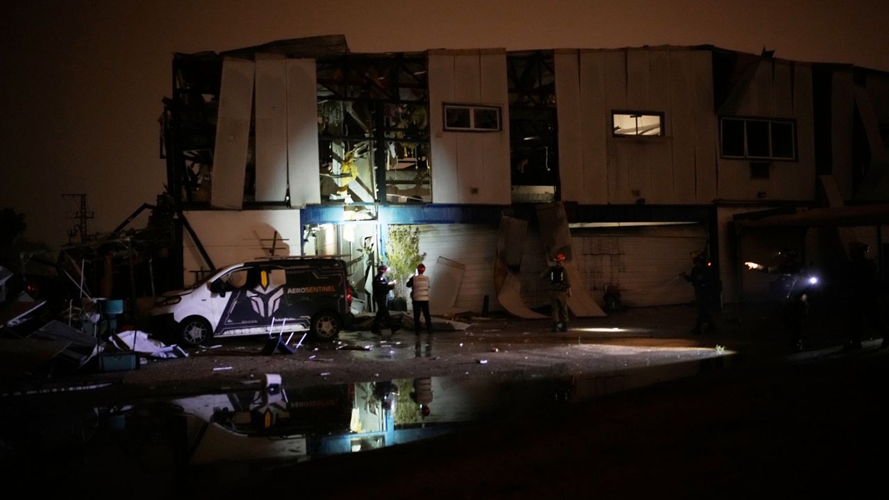 Israeli security forces and rescue teams inspect a site struck by an Iranian missile in Petah Tikva, Israel,Thursday, April 2, 2026. (AP Photo/Ohad Zwigenberg)