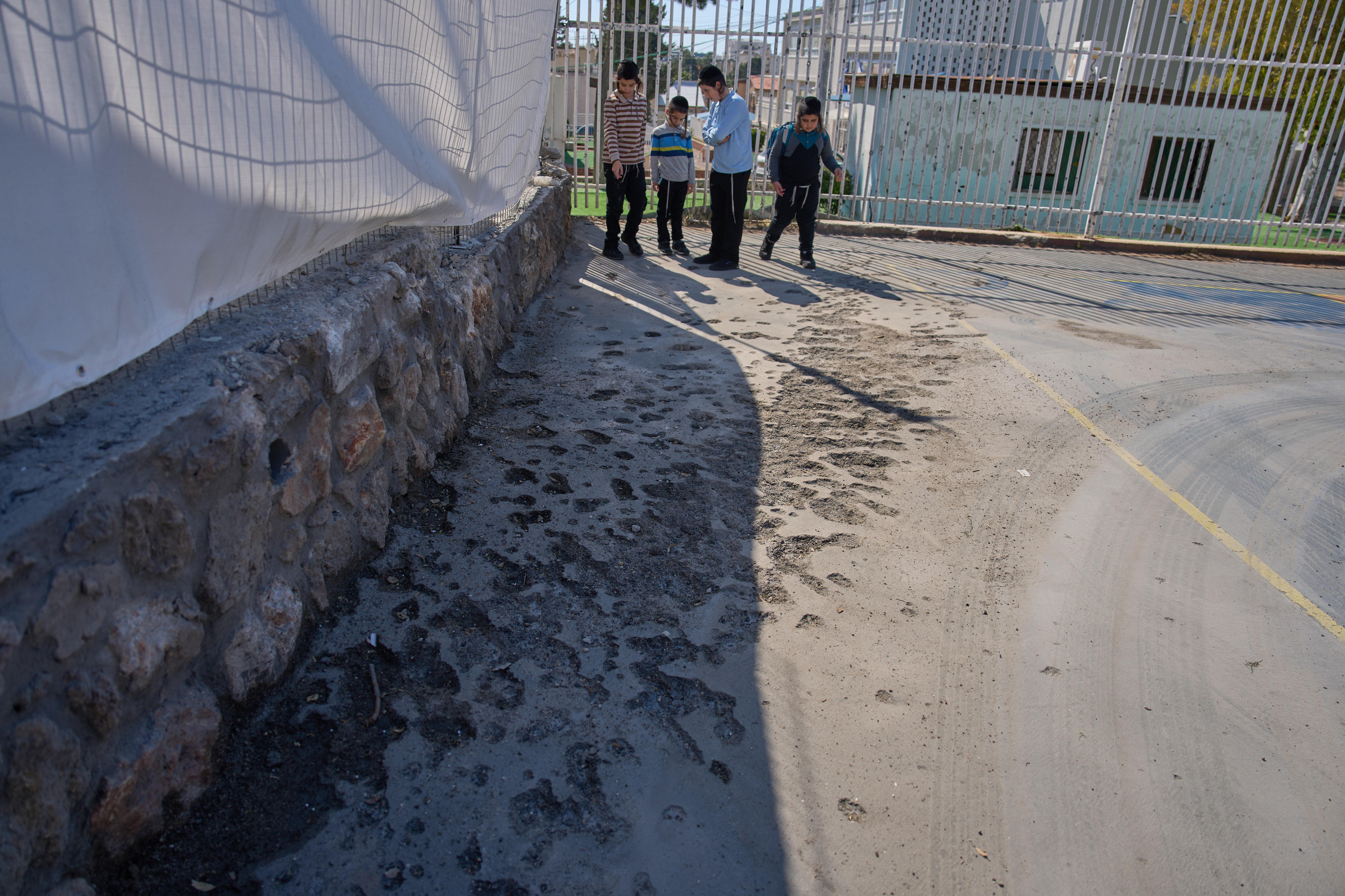 Children look at a damaged playground hit by projectiles launched from Lebanon in Nahariya, Israel.