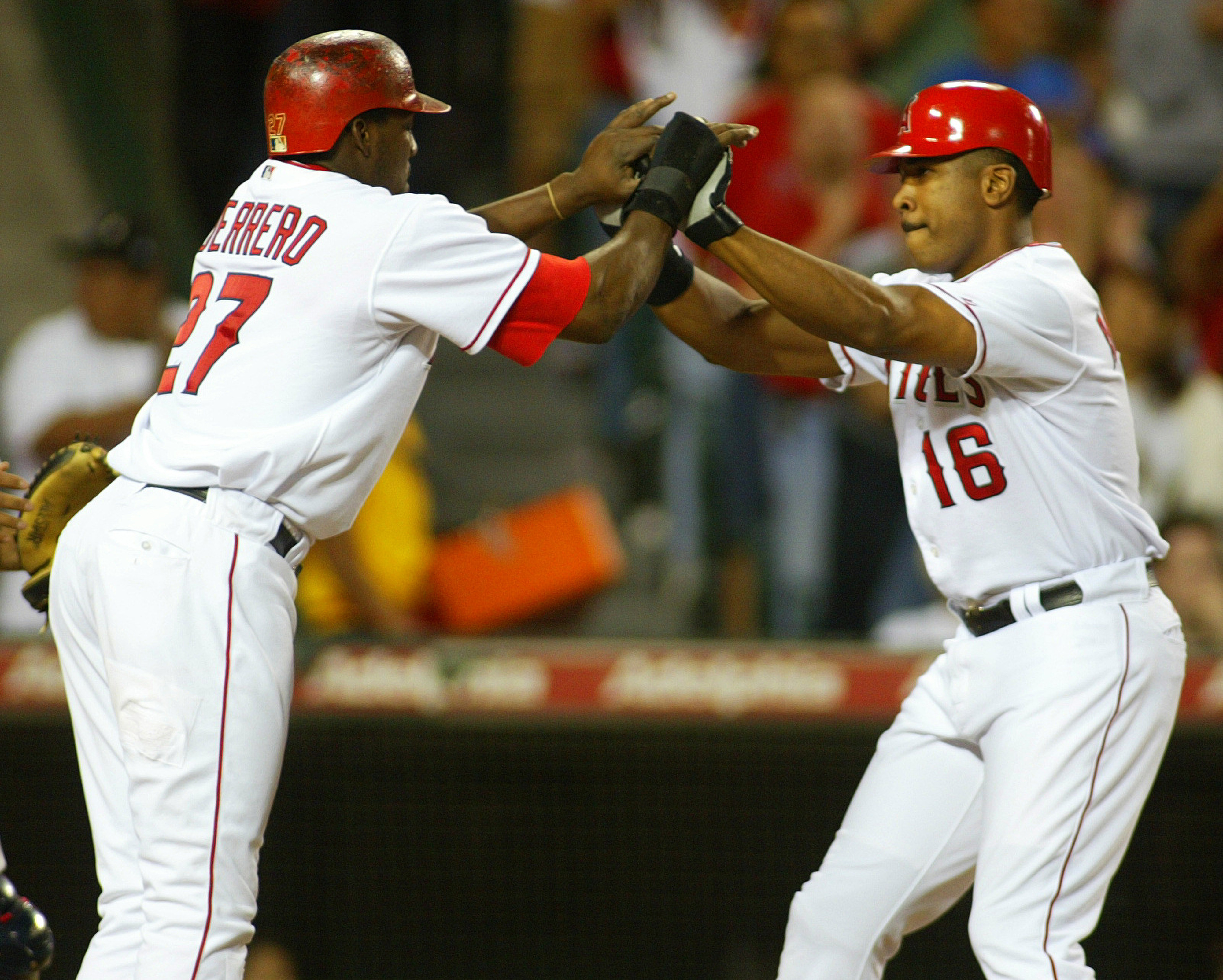 Vladimir Guerrero, left, and Garret Anderson high-five at home after...
