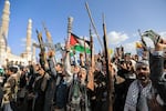 Supporters of the Iran-backed Houthi movement brandish their weapons as they rally in solidarity with Iran and Lebanon amid the U.S.-Israeli war with Iran, in Yemen's capital of Sanaa on Friday.