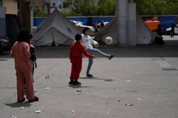 Displaced children play with a ball at a school backyard turned shelter in Sidon, Lebanon.