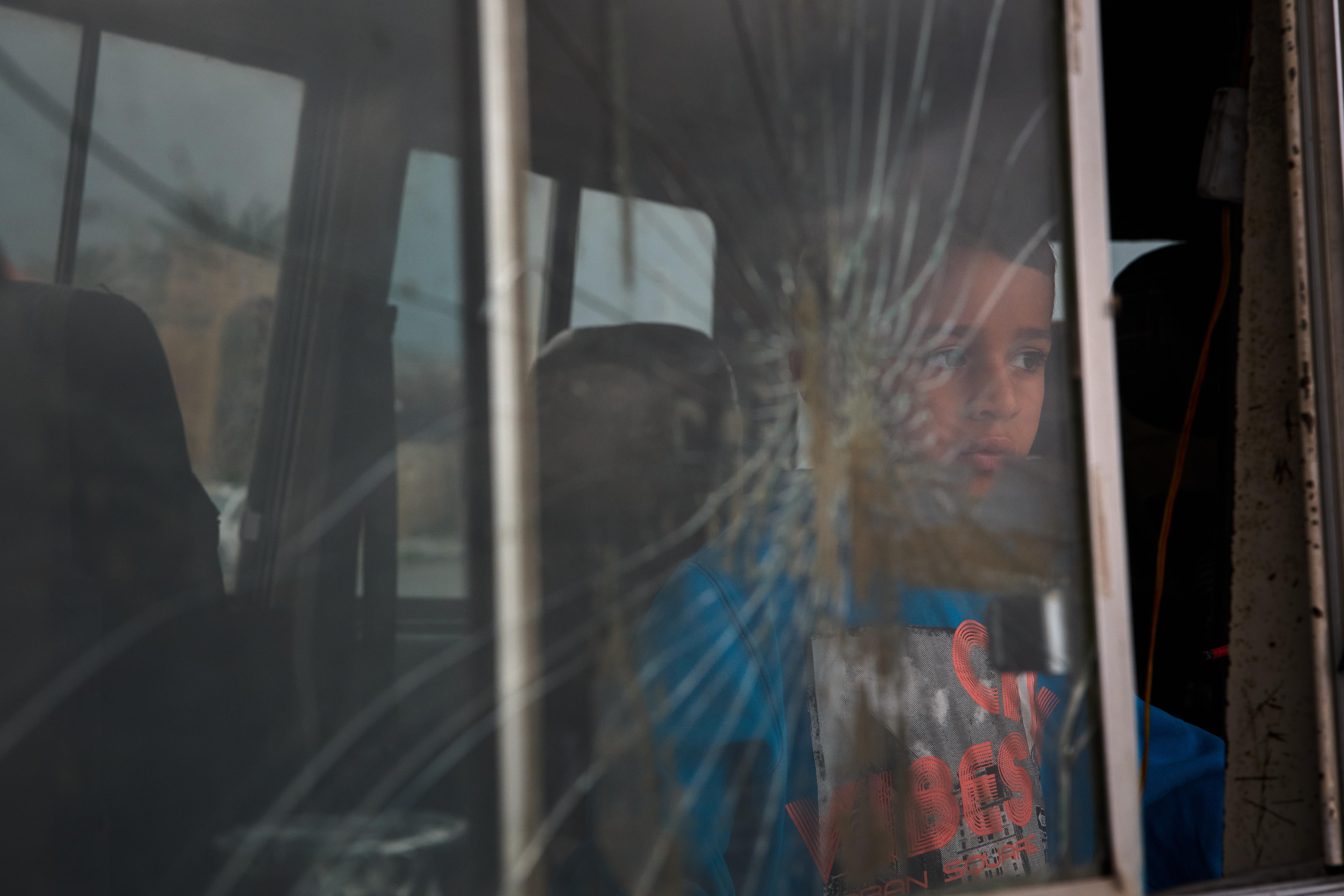 A boy who fled with his family following Israeli strikes in Lebanon sits inside their van.