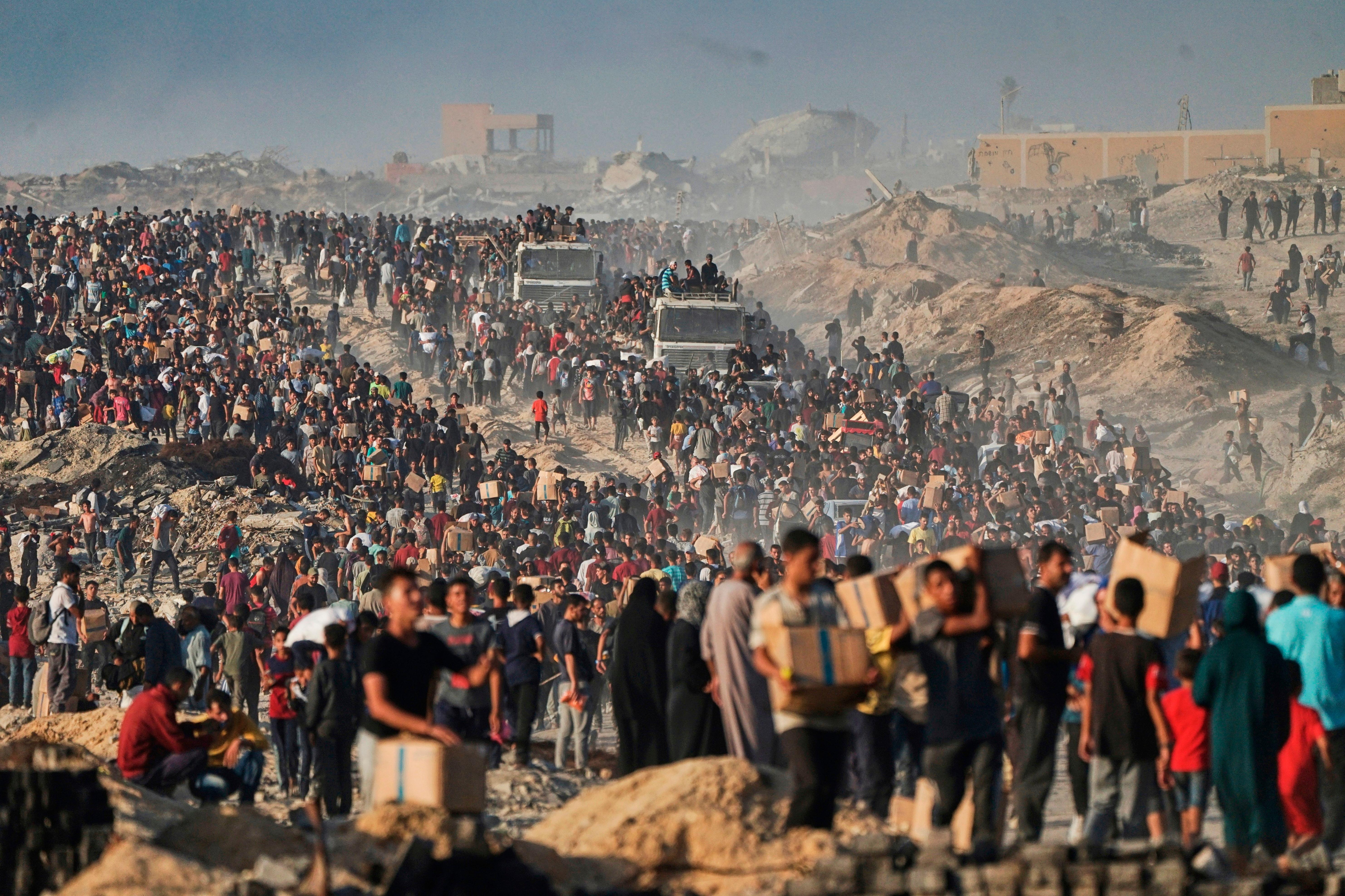 Palestinians carry sacks and boxes of food and humanitarian aid.
