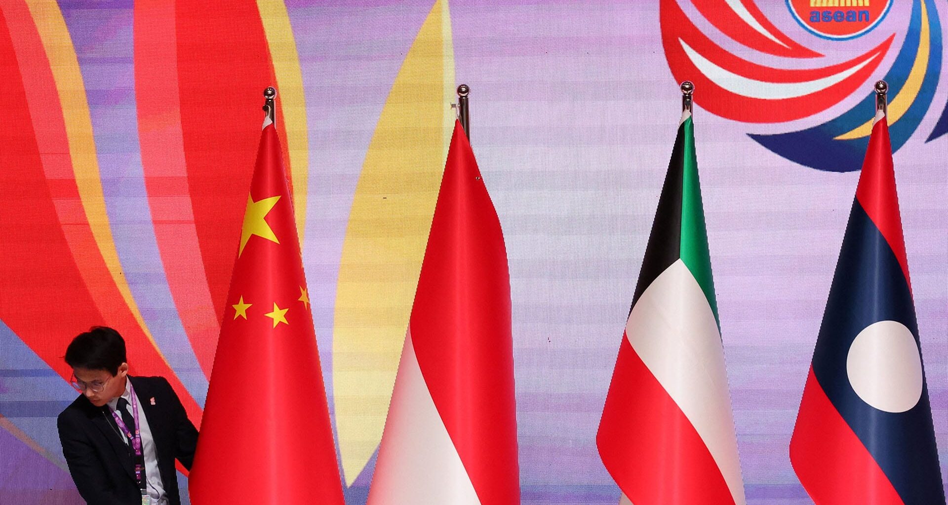 An unidentified man places a national flag on the ruins of the Sharif University of Technology's data center, which was struck on April 6 during ongoing military operations in Tehran, Iran, on April 7, 2026.