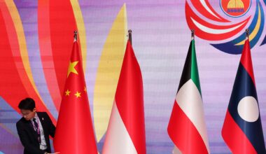 An unidentified man places a national flag on the ruins of the Sharif University of Technology's data center, which was struck on April 6 during ongoing military operations in Tehran, Iran, on April 7, 2026.