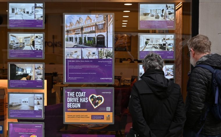 LONDON, ENGLAND - OCTOBER 30: People lok at houses for sale in an estate agents window in Mayfair on October 30, 2025 in London, United Kingdom. (Photo by John Keeble/Getty Images)