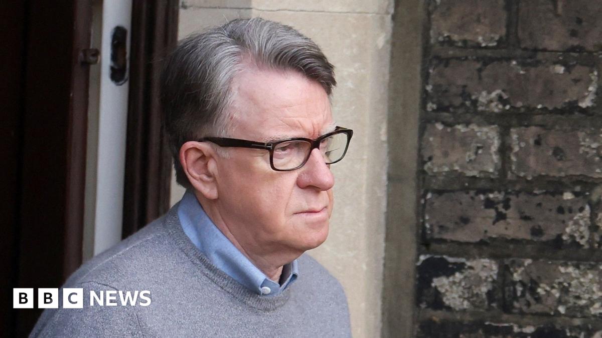 Mandelson standing outside his London home looking glum.