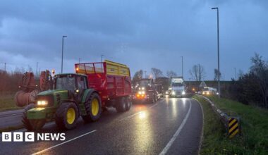 Undercover footage of a man in a suit, wearing glasses, in a hotel lobby.