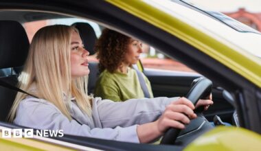 A young female learner driver in a yellow car