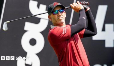 Sergio Garica tees off during a LIV Golf tournament with the branding in the background