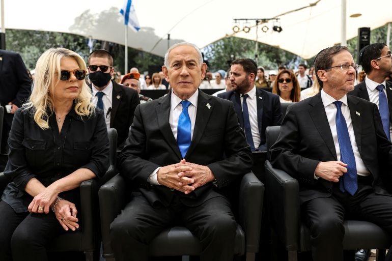 TOPSHOT - Israel’s Prime Minister Benjamin Netanyahu (C) and his wife Sara (L), sit alongside Israel’s President Isaac Herzog as they attend a ceremony commemorating Israel’s Remembrance Day for fallen soldiers, or Yom HaZikaron, at the Military Cemetery on Mount Herzl in Jerusalem on April 21, 2026.