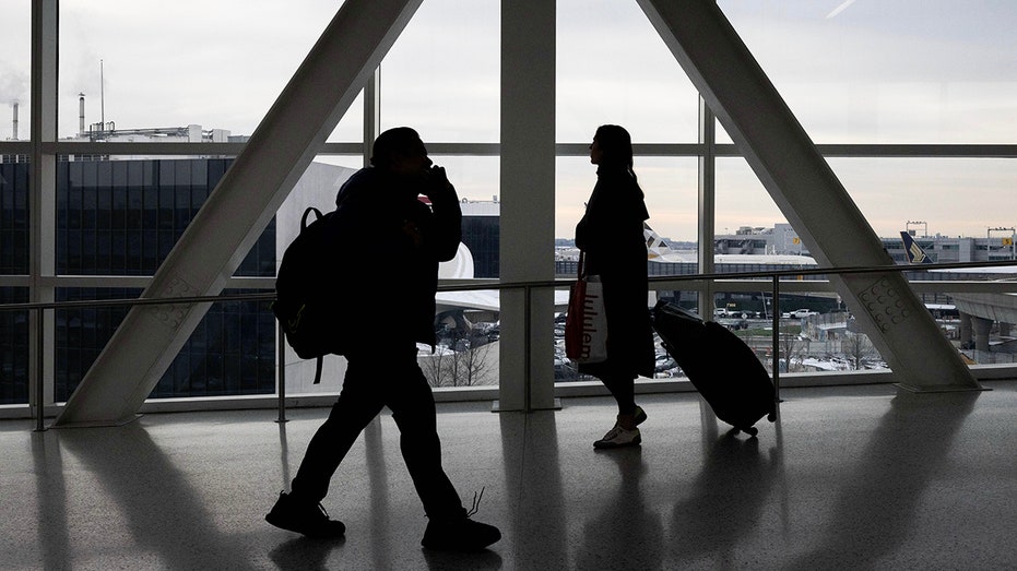 travelers walk through jfk airport