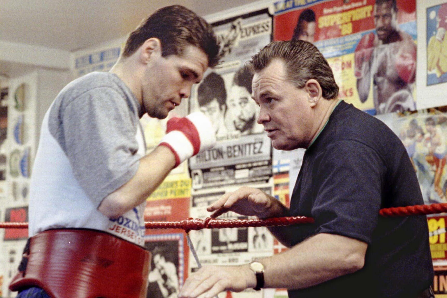 Alex and Dave Hilton speak to each other in a boxing practice ring.