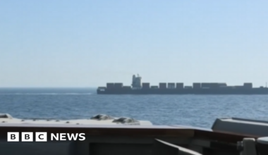 A vessel is seen in water off the side of another ship