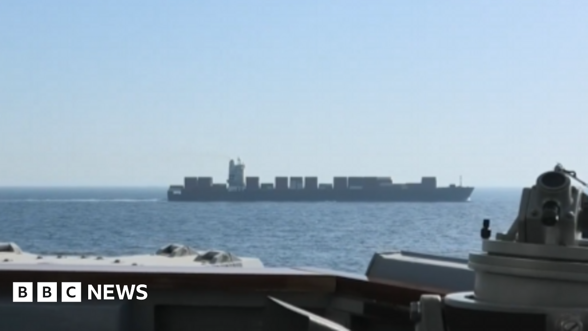 A vessel is seen in water off the side of another ship