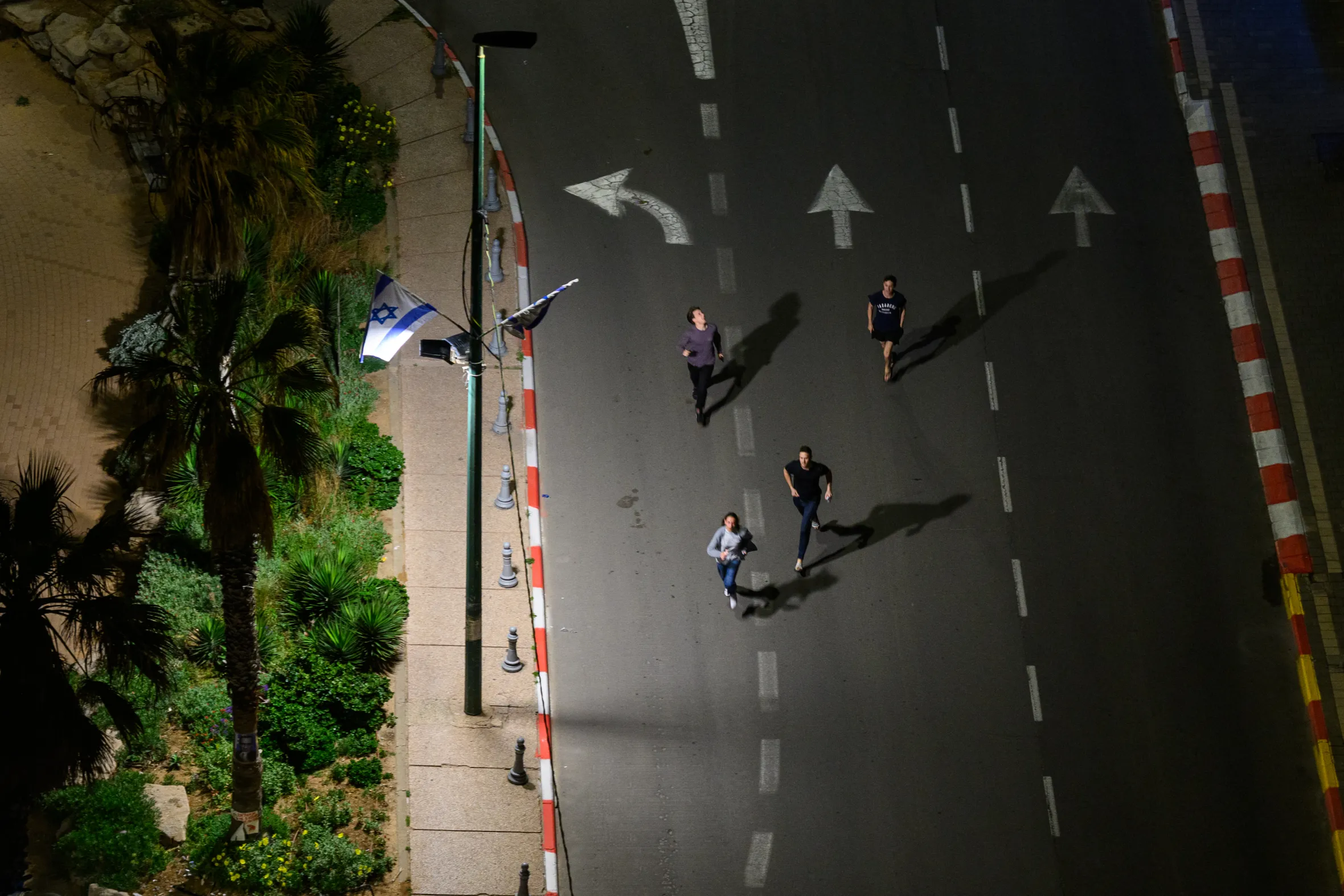 People running at night in Tel Aviv during missile fire.